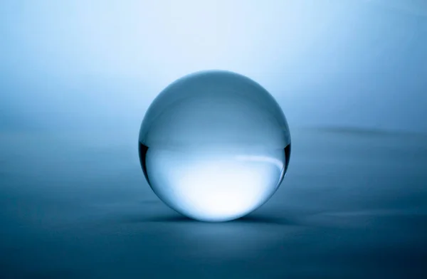 蓝色梯度背景下透明的水晶玻璃球球 — 图库照片