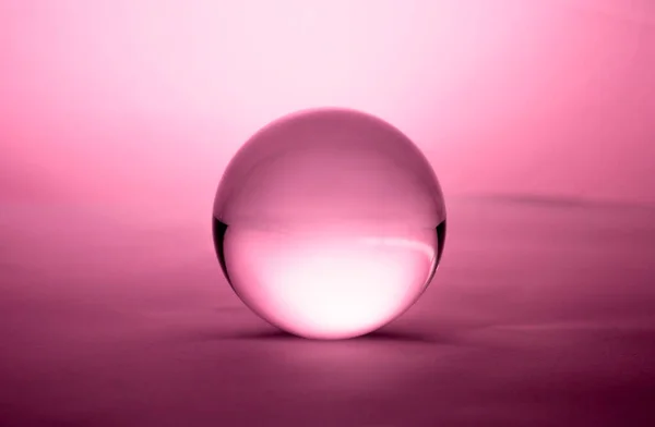 粉红梯度背景下透明的水晶玻璃球球 — 图库照片