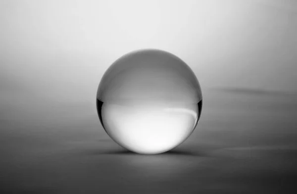 暗灰色のグラデーションの背景に透明なガラス球面 — ストック写真