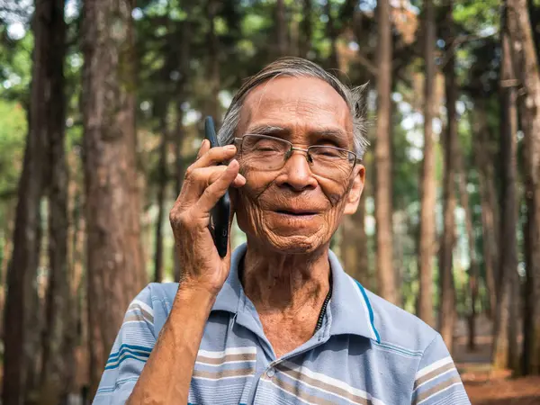 Oudere Aziatische Man Met Behulp Van Smartphone Tuin — Stockfoto