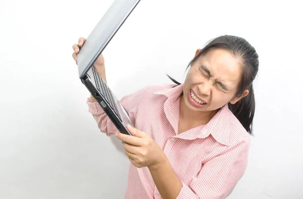 若いです怒っているアジアの女性オープン口悲鳴を上げるラップトップアップそれを捨てるために白い背景に隔離 — ストック写真