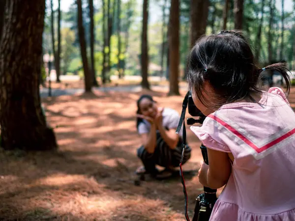 アジアの小さな子供の使用カメラは タイのチェンマイの松林で母親のために写真を撮っています リラクゼーション旅行コンセプト — ストック写真