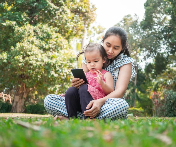 Mãe Asiática Sua Filha Sentada Chão Gramíneas Jardim Olhando Para — Fotografia de Stock