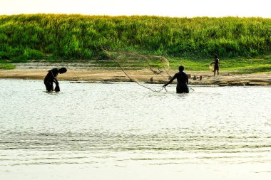 Balıkçılar Mekong Nehri boyunca güzel bir günbatımı boyunca yaşar.