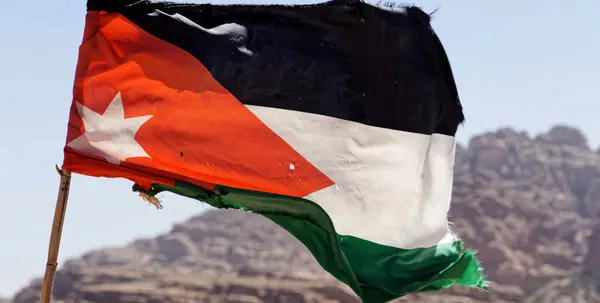 约旦瓦迪穆萨市Petra的大风峭壁上的约旦土地上被轻微敲碎的旗帜 — 图库照片