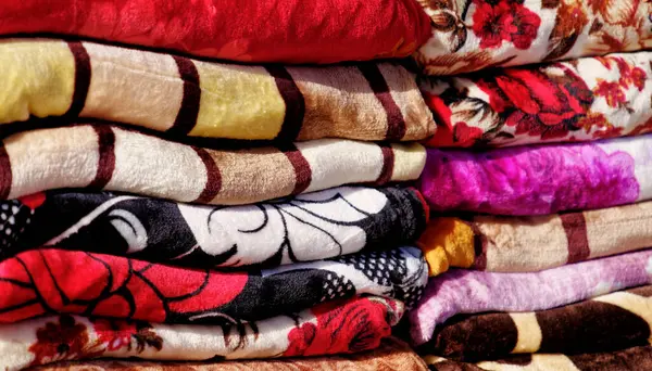 Colourful blankets at a sales stand for household articles on the main street of Aqaba, Jordan