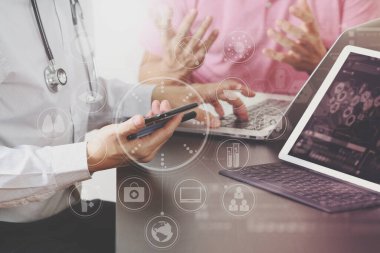Tıbbi ortak çalışma konsepti, Doktor akıllı telefon ve dizüstü bilgisayarla çalışıyor.