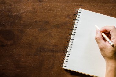 Kırpılmış kişi deftere yazıyor