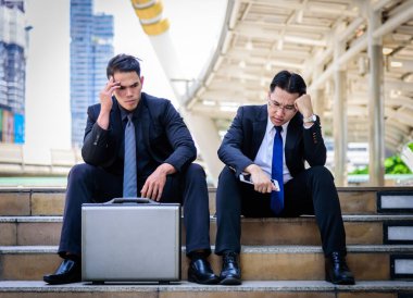 Asyalı iki iş adamı üzgün ve hayal kırıklığına uğramış hisseder. 