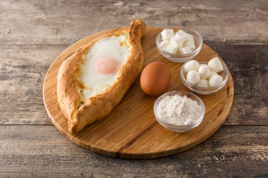 Ahşap masada peynir ve yumurta ile Geleneksel Adjarian Gürcü khachapuri