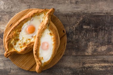Ahşap masada peynir ve yumurta ile Geleneksel Adjarian Gürcü khachapuri