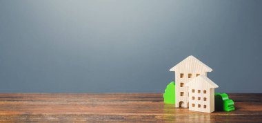Gri bir arka planda konut figürleri. Satın alma ve satma, kiralık konut. Apartman sahipleri. İnşaat endüstrisi gayrimenkul, bakım hizmetleri. İpotek kredisi
