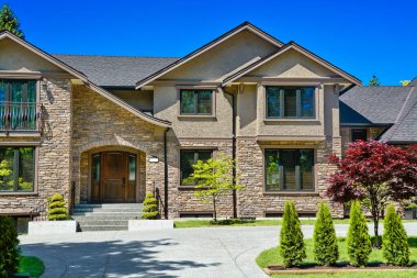 Önünde mavi gökyüzü arka planında beton yol olan lüks aile evi.