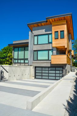 Detached house with wide garage for two cars and concrete driveway in front