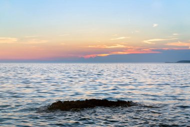 Plaj kayalar ve bulutlu bir gökyüzü