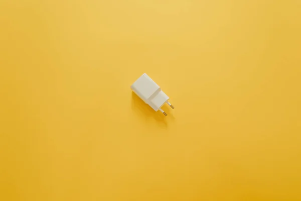 黄色のテーブルの上に白い充電器 — ストック写真