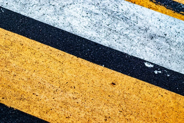yellow and white line crossing line on road