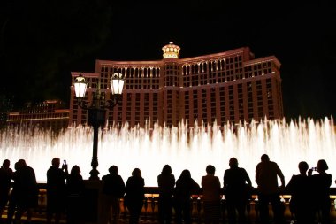 Las Vegas 'taki Bellagio Fıskiyeleri gösterisine hayran insanların siluetleri ile gece sahnesi