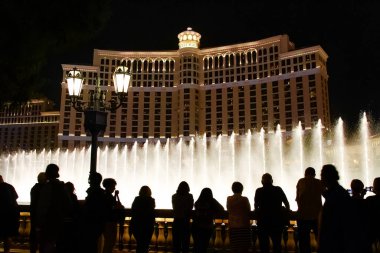 Las Vegas 'taki Bellagio Fıskiyeleri gösterisine hayran insanların siluetleri ile gece sahnesi