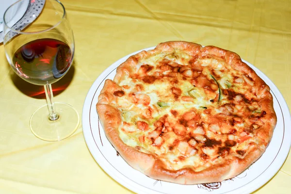 a plate with pizza and wine on the table