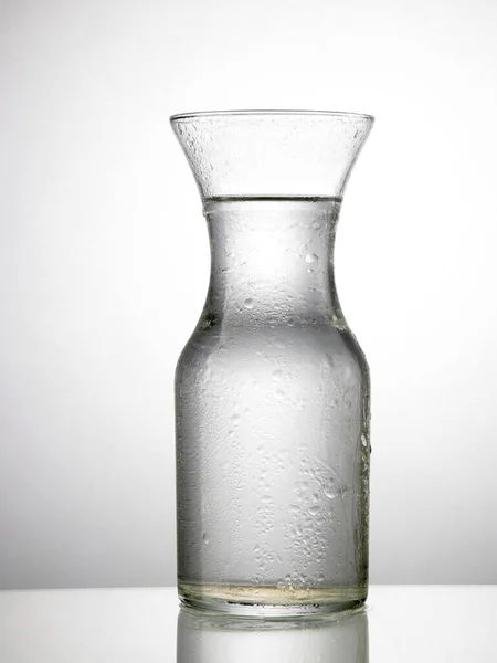 グレイバックグラウンドで飲料水でガラスのクローズアップビュー — ストック写真
