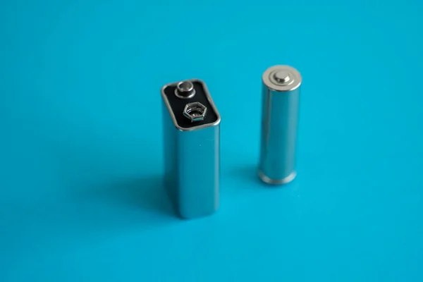 高压电压9V电池和碱性Aa电池蓝色背景 — 图库照片