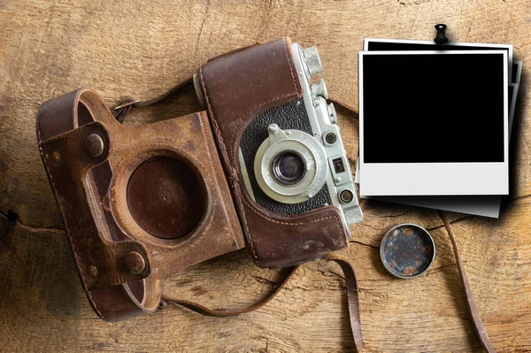 Vintage film camera with leather case and polaroid frame for mock up on old wooden bakground