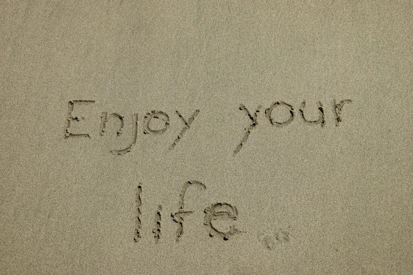 Nauti Elämästäsi Onnellisuuden Käsite Positiivinen Ajattelu Inspiroiva Lainaus Kirjoitettu Hiekkarannalle — kuvapankkivalokuva