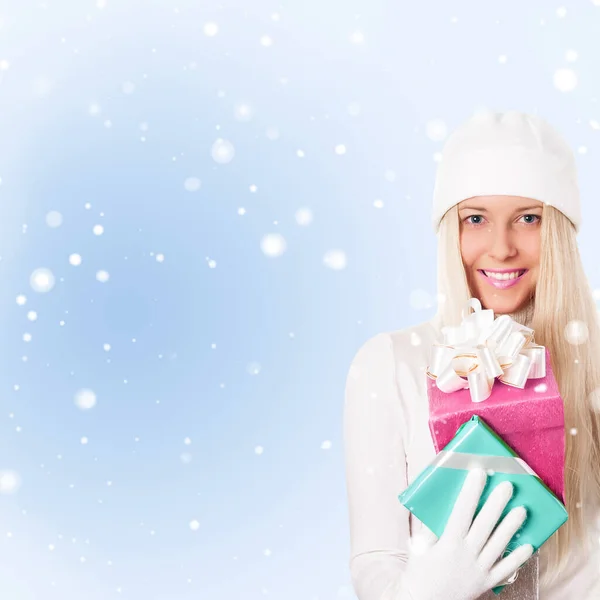 在雪地背景下拥有圣诞礼物的快乐女人 — 图库照片