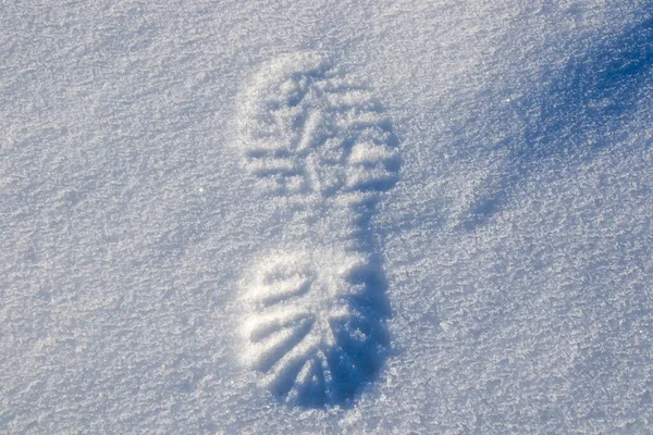 Footprint on the snow, shoe print. Snow background. Copy space.
