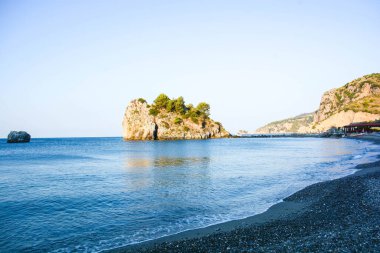 Güzel mavi deniz manzarası ve adada kayalar.