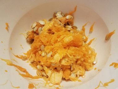 pumpkin seeds and orange pulp in container