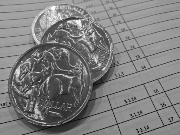 Three silver coins of Australian dollars on invoice sheet