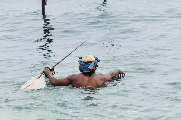 Sri Lanka 'daki Stilt balıkçıları oltasına kadar yüzüyorlar ve ellerinde kithul sopaları var.