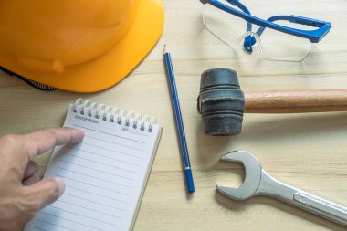 Fabrikayı ya da sanayiyi kontrol etmek için elinde not defteri olan elleri tutan adamlar.