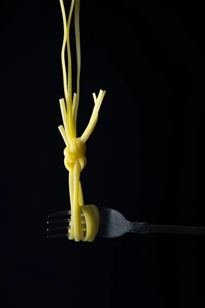 黒の背景の前にフォークの上のスパゲッティ — ストック写真