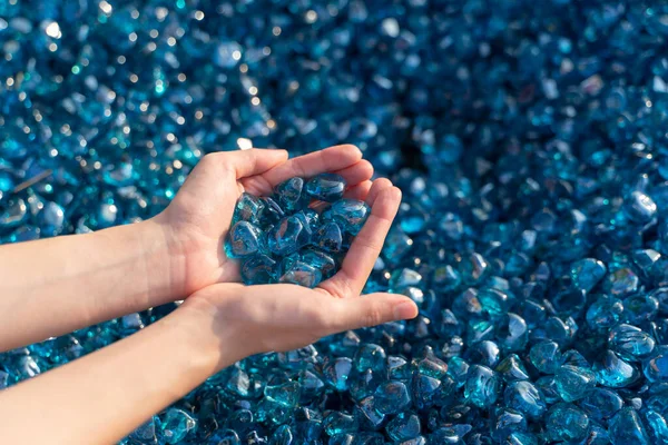 A close up of blue crystal rocks in woman hand.