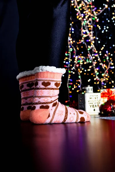 クリスマスツリーの近くのクリスマスカラフルな靴下の女性の足 — ストック写真