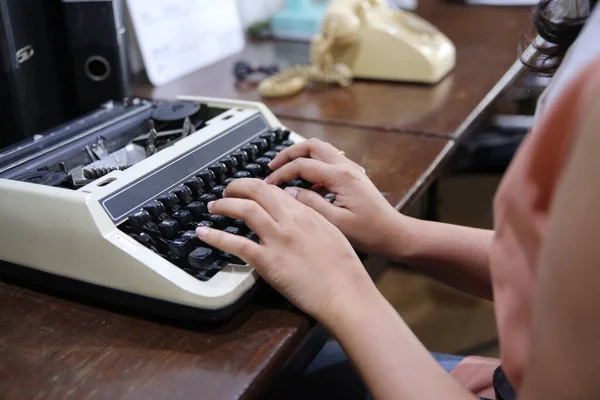对打字机上打字的女用手进行密切的观察 — 图库照片