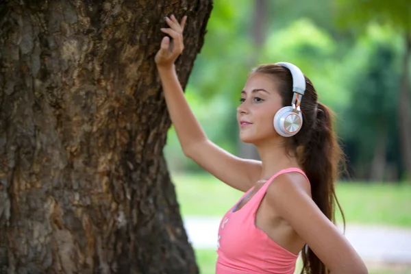 young active woman with head phone exercise in park.