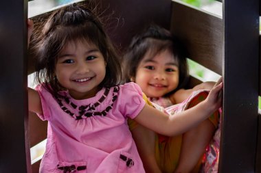 Pretty asian identical twins while enjoying and playing on a playground