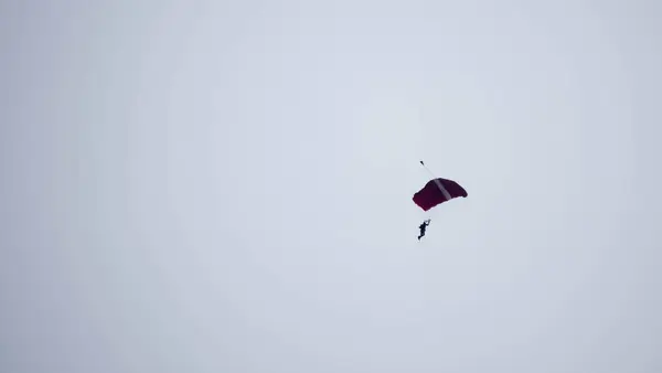 空中で滑っている間にシルエットパラシュートが焦らずぼやけ — ストック写真