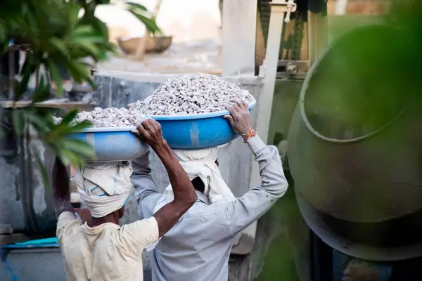 インドの不動産 オフィスの作成のためのコンクリートを作るためにミキサーに荷を積むために頭に砂 セメント 石および水を運ぶインドの下請け労働者のショットでズーム — ストック写真