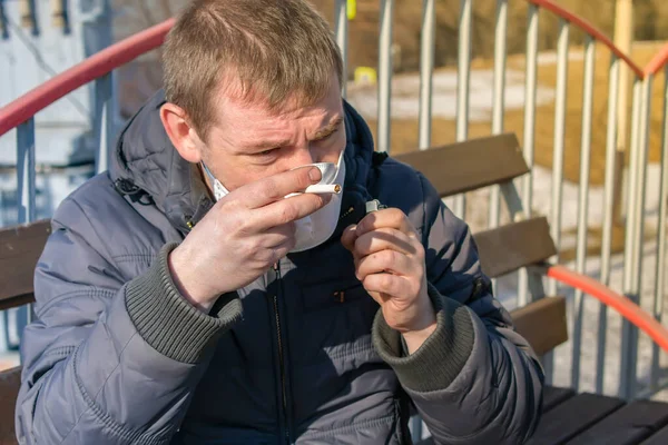 Tıbbi Maskeli Hasta Bir Adam Sigara Yakmaya Çalışıyor — Stok fotoğraf