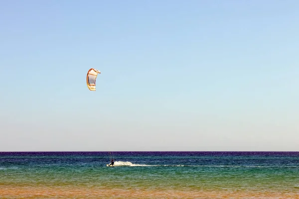 滑らかな紺碧の水をサーフィンするカイトサーフィン レクリエーションスポーツ 男は海の水の中でカイトボードに乗っています 極端なスポーツだ ジャンプ — ストック写真
