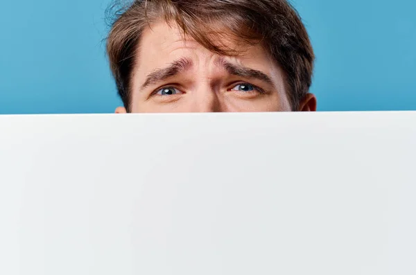 a man peeking out from behind a banner advertising Copy Space close-up