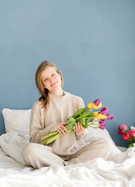Mujer Feliz Sentada Cama Con Pijamas Sosteniendo Flores Tulipán Ramo — Foto de Stock