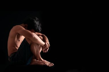 Üzgün adam kasvetli bir şekilde dizine sarıldı. Karanlık odada yerde tek başına oturuyordu.