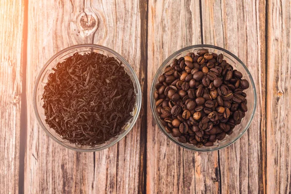 木のテーブルのカップで包まれたインファーおよびローストされたコーヒーの穀物のための茶葉 — ストック写真