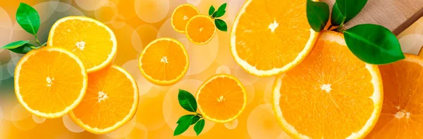 Sliced orange on a bright orange background. Oranges in the panoramic image. Panorama, a banner with space for text or insertion. Pieces of citrus fruit.